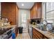 Functional kitchen with wood cabinets, granite countertops, and stainless steel appliances at 130 E Longview St # Apt K, Chapel Hill, NC 27516