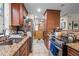 View of kitchen with wood cabinets, granite countertops, and stainless steel appliances at 130 E Longview St # Apt K, Chapel Hill, NC 27516