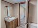 Bathroom with a wood vanity, a sink with granite countertops, and a view into another room at 1326 Stephens Dr, Roxboro, NC 27573
