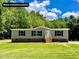New construction single-story home with gray siding, black shutters, and well-maintained lawn at 1326 Stephens Dr, Roxboro, NC 27573