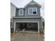 Two-story home featuring an attached garage with grey siding and brick accents at 1344 Bessie Ct, Wake Forest, NC 27587