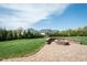 Serene backyard with a stone patio, fire pit, and lush lawn at 135 Brocks Trce, Burlington, NC 27215
