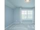 Bedroom with a large window and neutral walls, carpet, and white curtains at 135 Brocks Trce, Burlington, NC 27215