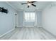 A clean, bright bedroom featuring laminate flooring, a ceiling fan and shuttered windows at 135 Brocks Trce, Burlington, NC 27215