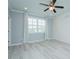A clean, bright bedroom featuring laminate flooring, a ceiling fan and shuttered windows at 135 Brocks Trce, Burlington, NC 27215