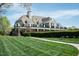 Elegant clubhouse with covered balcony, stone accents, and lush lawn at 135 Brocks Trce, Burlington, NC 27215