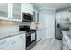 Kitchen featuring granite counters, stainless steel appliances, white cabinetry and laminate flooring at 135 Brocks Trce, Burlington, NC 27215