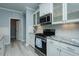 Kitchen featuring granite counters, stainless appliances, white cabinetry and laminate flooring at 135 Brocks Trce, Burlington, NC 27215