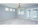 Bright, airy living room with light gray wood flooring, white trim and a stylish chandelier at 135 Brocks Trce, Burlington, NC 27215