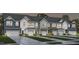 A row of newly built townhomes featuring unique, colorful facades and modern garage doors in a welcoming neighborhood at 1367 Bessie Ct, Wake Forest, NC 27587
