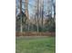 Fenced backyard featuring well maintained grass and lush surrounding trees, offering privacy at 1404 Rhea Dr, Garner, NC 27529