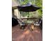 Outdoor dining set and grill under a large umbrella on a stained, wooden deck at 1404 Rhea Dr, Garner, NC 27529