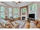 Cozy living room with a fireplace, hardwood floors, large windows, and comfortable seating at 1404 Rhea Dr, Garner, NC 27529
