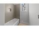 Bathroom with a white bathtub and gray tile accent wall, offering a calming and serene space at 1425 Lake Adventure Ct, Raleigh, NC 27613
