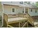 Wood backyard deck with steps going down to the yard and house with light gray siding at 1508 Middle Ridge Dr, Willow Springs, NC 27592