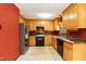Spacious kitchen features stainless steel refrigerator, black oven and light wood cabinetry at 1508 Middle Ridge Dr, Willow Springs, NC 27592