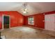 Bright living room featuring orange walls, vaulted ceiling with fan, window and door at 1508 Middle Ridge Dr, Willow Springs, NC 27592