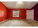 Bright living room featuring orange walls, with a window and a white front door at 1508 Middle Ridge Dr, Willow Springs, NC 27592