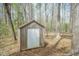 Simple backyard shed with a white door in a wooded area at 1508 Middle Ridge Dr, Willow Springs, NC 27592