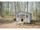 A small shed with double doors in the backyard surrounded by trees at 1508 Middle Ridge Dr, Willow Springs, NC 27592