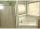 Clean bathroom featuring a garden tub and glass shower with natural light at 1623 Rogers Pointe Ln, Creedmoor, NC 27522