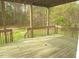 Back porch deck and rail featuring the green and brown yard at 1623 Rogers Pointe Ln, Creedmoor, NC 27522