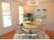 Staged dining room featuring a round table, chandelier, and natural light from the surrounding windows at 1623 Rogers Pointe Ln, Creedmoor, NC 27522