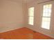 Empty living room with hardwood floors and two windows providing ample natural light at 1623 Rogers Pointe Ln, Creedmoor, NC 27522