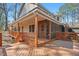 Covered back porch with wooden decking, stairs, and porch screens at 167 Coachmans Cove Rd, Four Oaks, NC 27524