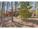 Home exterior featuring a large backyard, deck, screened porch, and lush trees at 167 Coachmans Cove Rd, Four Oaks, NC 27524