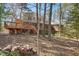 Home exterior featuring a large backyard, deck, screened porch, and lush trees at 167 Coachmans Cove Rd, Four Oaks, NC 27524