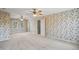 Large bedroom with floral wallpaper, two ceiling fans and natural light from exterior windows at 167 Coachmans Cove Rd, Four Oaks, NC 27524