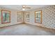 A spacious bedroom features floral wallpaper, hardwood floors, and plentiful natural light through the windows at 167 Coachmans Cove Rd, Four Oaks, NC 27524