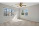 Bedroom features neutral walls, carpet, and a ceiling fan with natural light from windows at 167 Coachmans Cove Rd, Four Oaks, NC 27524