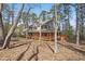 A two-story home has a large wrap-around porch surrounded by many trees at 167 Coachmans Cove Rd, Four Oaks, NC 27524