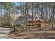 Two-story home with a full front porch nestled in mature trees, long drive way leading to the garage at 167 Coachmans Cove Rd, Four Oaks, NC 27524