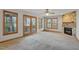 Bright living room with a stone fireplace, deck access and three large windows at 167 Coachmans Cove Rd, Four Oaks, NC 27524