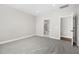 Spacious bedroom with neutral paint, plush carpeting, and doors leading to the bathroom at 1801 Angelonia Way, Fuquay Varina, NC 27526