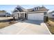 Attractive exterior view with well-manicured lawn, spacious driveway and a mix of brick and siding accents at 1801 Angelonia Way, Fuquay Varina, NC 27526