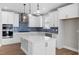 Stylish kitchen with white cabinetry, stainless steel appliances, a blue backsplash and island with quartz countertop at 1801 Angelonia Way, Fuquay Varina, NC 27526