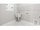 Functional laundry room with utility sink, white tile flooring, and ample space at 1801 Angelonia Way, Fuquay Varina, NC 27526