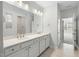 Bathroom featuring double sinks with white cabinets, tile flooring and access to a tiled shower at 1805 Angelonia Way, Fuquay Varina, NC 27526