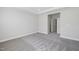 Spacious carpeted bedroom with white trim, a tray ceiling and natural light, adjacent to an open doorway at 1805 Angelonia Way, Fuquay Varina, NC 27526