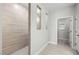 Bright hallway with tile floors, leading to a tiled walk-in shower and a glimpse of a walk-in closet at 1805 Angelonia Way, Fuquay Varina, NC 27526