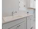 Well-lit laundry room featuring white cabinetry, a sink with a chrome faucet and bright quartz countertops at 1805 Angelonia Way, Fuquay Varina, NC 27526