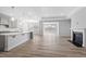 Open floor plan with kitchen island, hardwood floors, fireplace, and connecting dining/living room area at 1805 Angelonia Way, Fuquay Varina, NC 27526