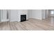 Cozy living room with hardwood flooring, a classic fireplace, and bright natural light at 1805 Angelonia Way, Fuquay Varina, NC 27526