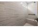 Walk-in shower featuring gray-tone tiling with a built-in niche and bench, and bronze fixtures at 1805 Angelonia Way, Fuquay Varina, NC 27526