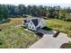 Aerial view of a modern farmhouse with attached garage, landscaped yard, and expansive lawn at 1886 Mays Crossroad Rd, Louisburg, NC 27549