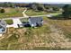 A modern farmhouse-style home with dark roof and white siding with a long concrete driveway and large lawn at 1886 Mays Crossroad Rd, Louisburg, NC 27549